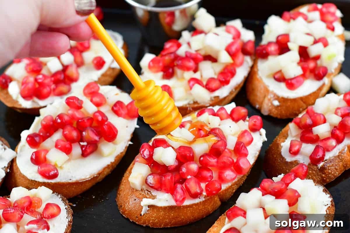 drizzling honey over pomegranate crostini