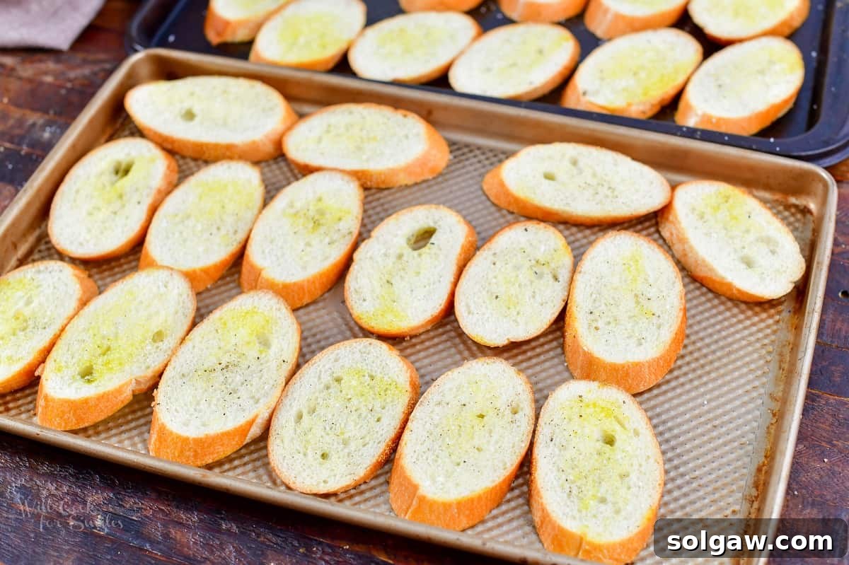 bread slices topped with oil, salt, and pepper on baking sheet