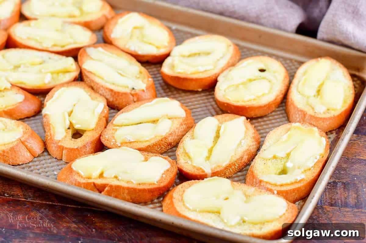 crostini on a baking sheet with melted Brie