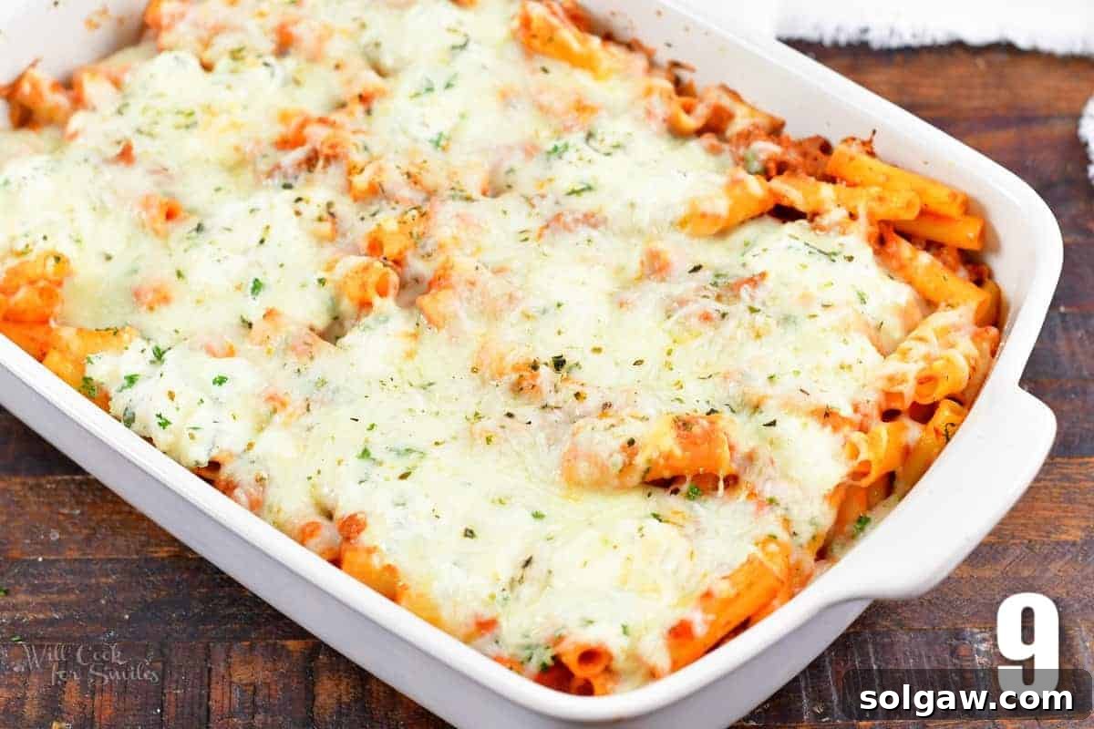 Freshly baked ziti, golden and bubbling, in a white casserole dish, ready to be served.