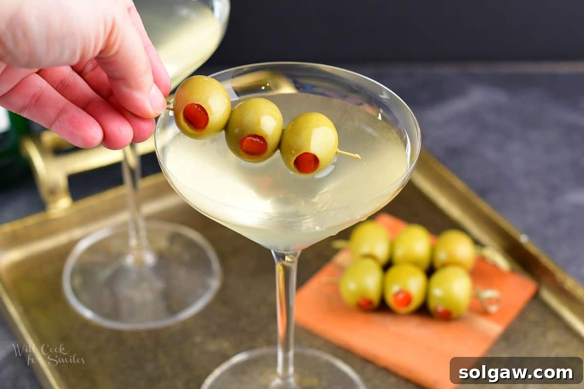 The Maverick's Martini 7 adding olives to the martini in a glass