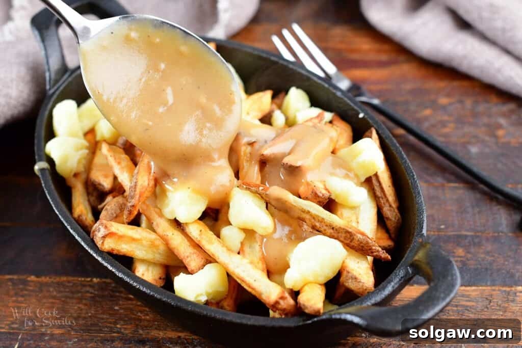 Homemade Poutine Perfection 13 adding gravy on top of fries and cheese