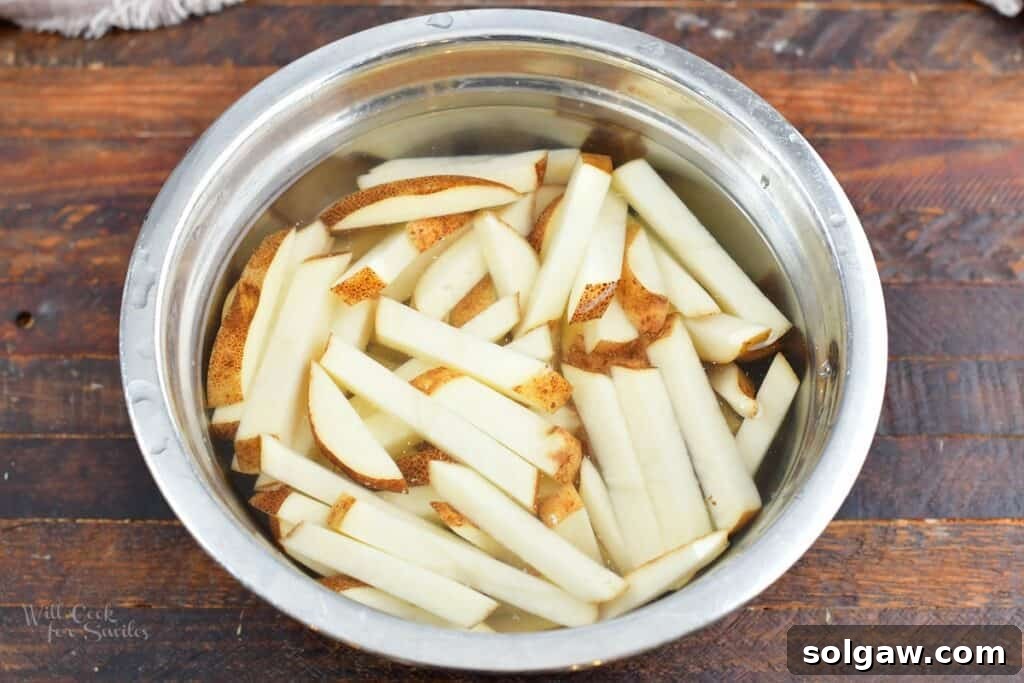 Homemade Poutine Perfection 5 cut potatoes soaking in water