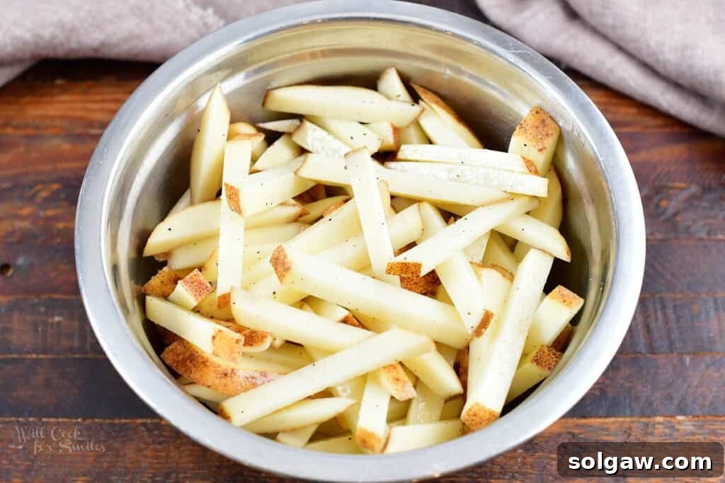 Homemade Poutine Perfection 6 cut and seasoned fries in a mixing bowl