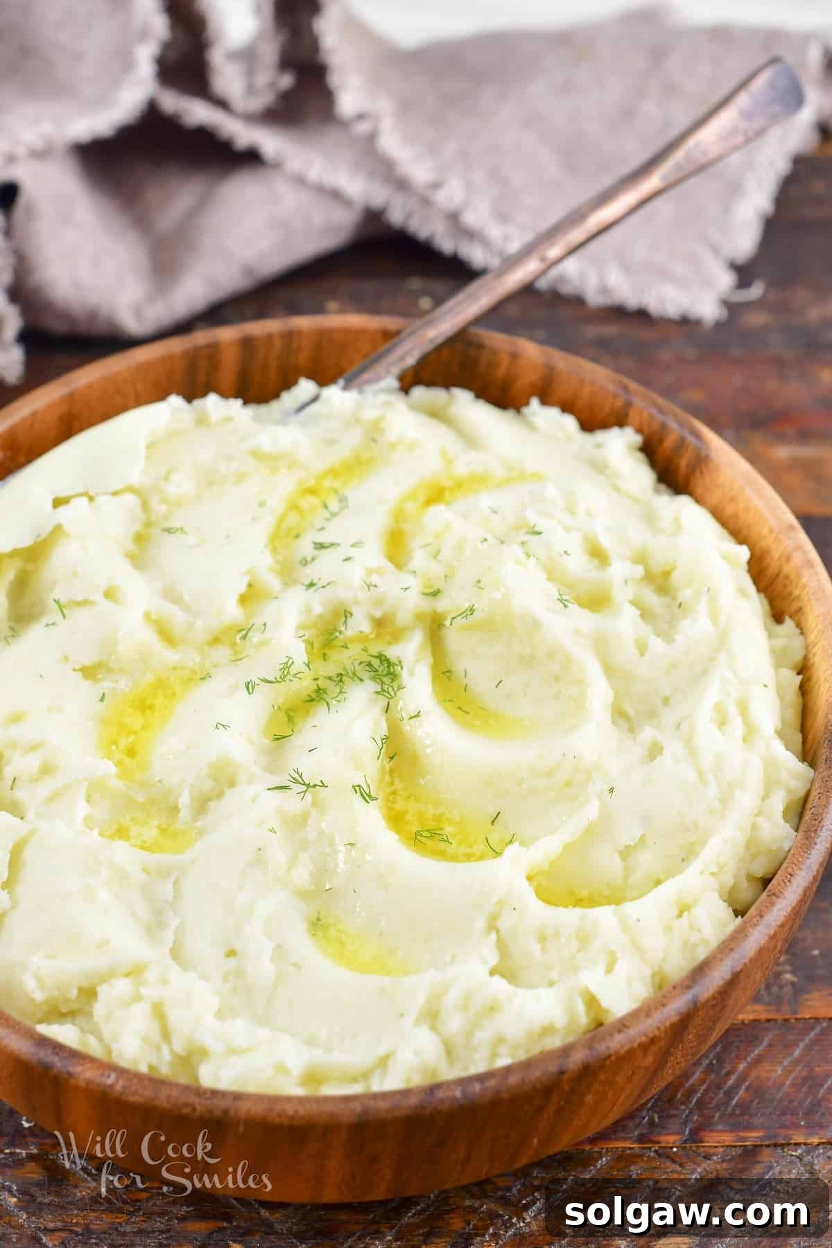 Perfectly Creamy Homemade Mashed Potatoes 8 smooth and fluffy mashed potatoes with butter and a spoon in a wooden bowl.