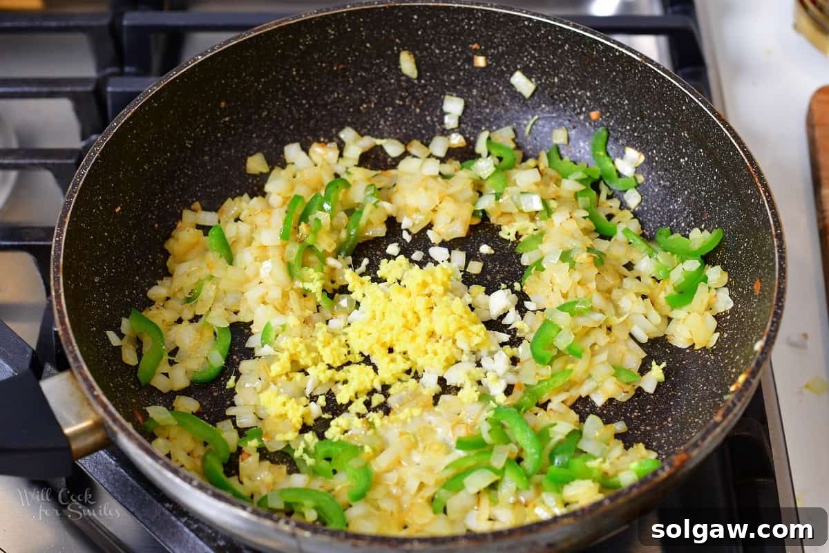 Butter Chicken Murgh Makhani 8 Sautéed onions, jalapeños, minced garlic, and ginger fragrant in a pan, ready for the next step.