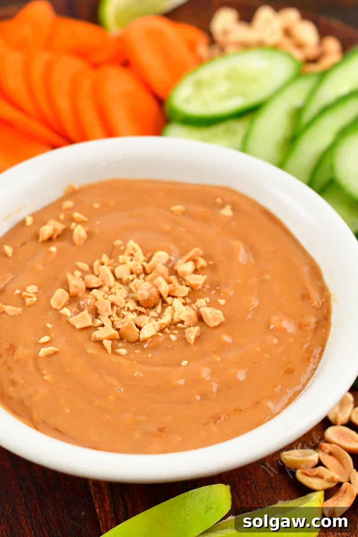 A pristine white bowl filled with creamy peanut sauce, elegantly garnished with a sprinkle of crushed peanuts, ready for serving.