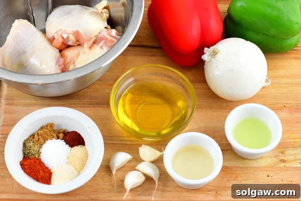 Zesty Air-Fried Southwest Chicken Thighs 3 A selection of fresh ingredients including bell peppers, red onion, chicken thighs, and various spices laid out for Air Fryer Southwest Chicken Thighs.