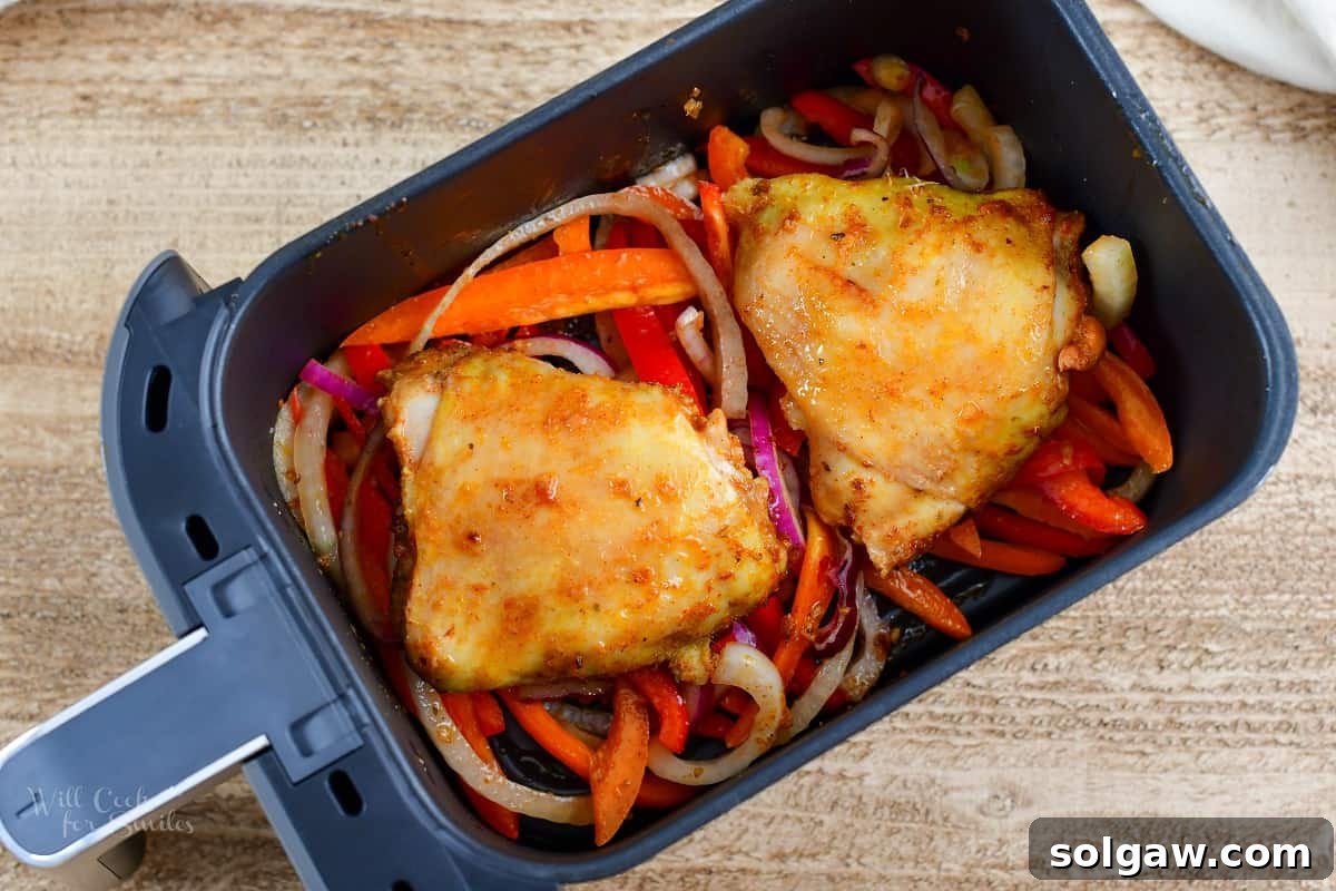 Zesty Air-Fried Southwest Chicken Thighs 7 Chicken thighs nearing completion in the air fryer, with visibly crispy skin.