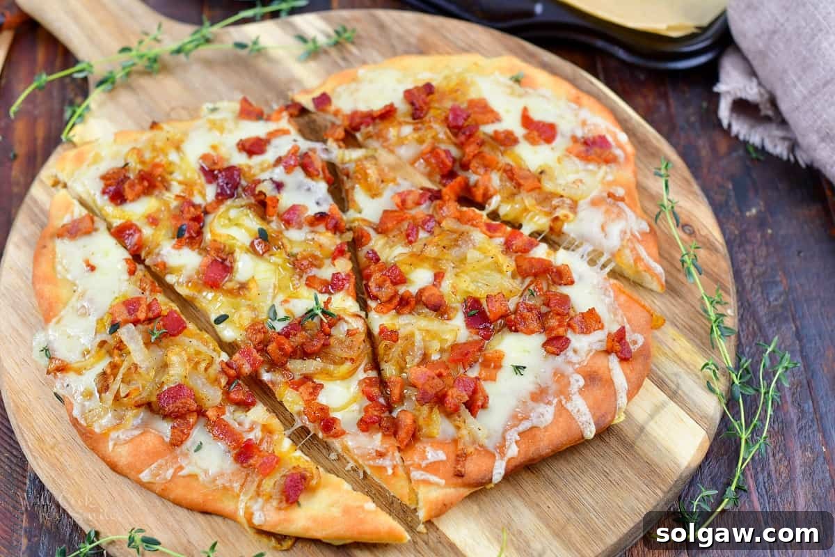 Sweet Golden Onion Smoky Bacon Gruyere Flatbread 13 closeup of sliced flatbread pizza with bacon and onion, showing the melted cheese and crispy texture