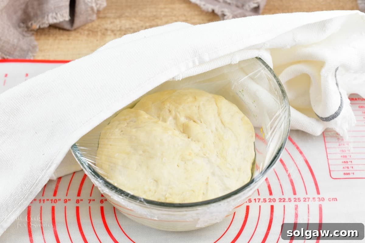 Sweet Golden Onion Smoky Bacon Gruyere Flatbread 8 raised dough for the crust in the glass bowl, demonstrating successful yeast activation and proofing