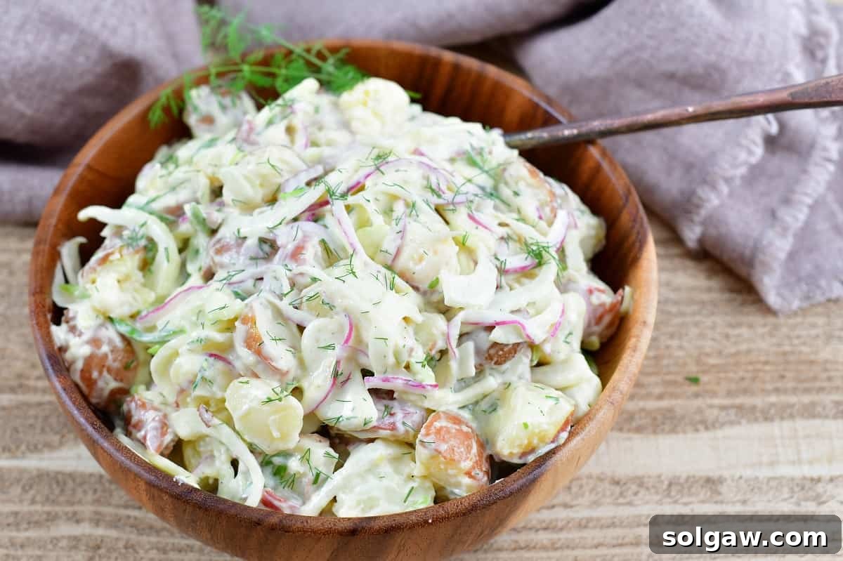 Top-down view of the mixed fennel potato salad in a ceramic bowl, ready to be served.