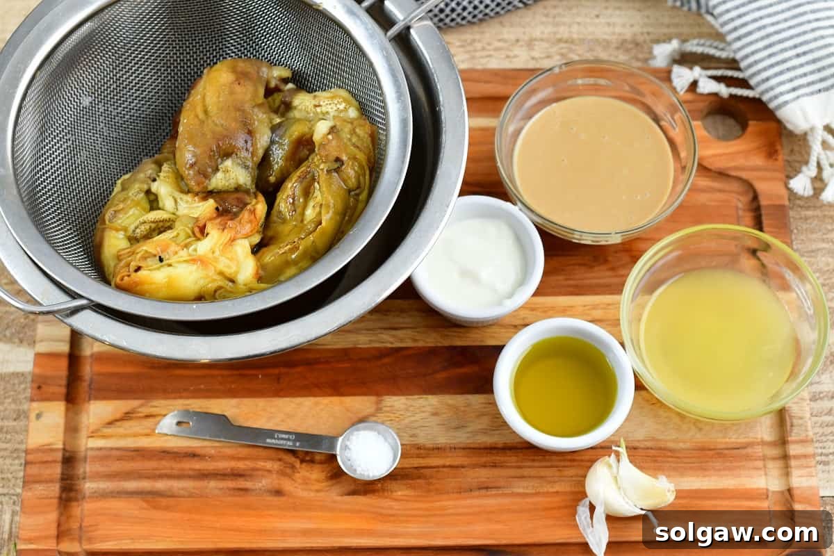 Smoky Aubergine Mezze 3 Ingredients for making homemade Baba Ganoush laid out on a wooden board