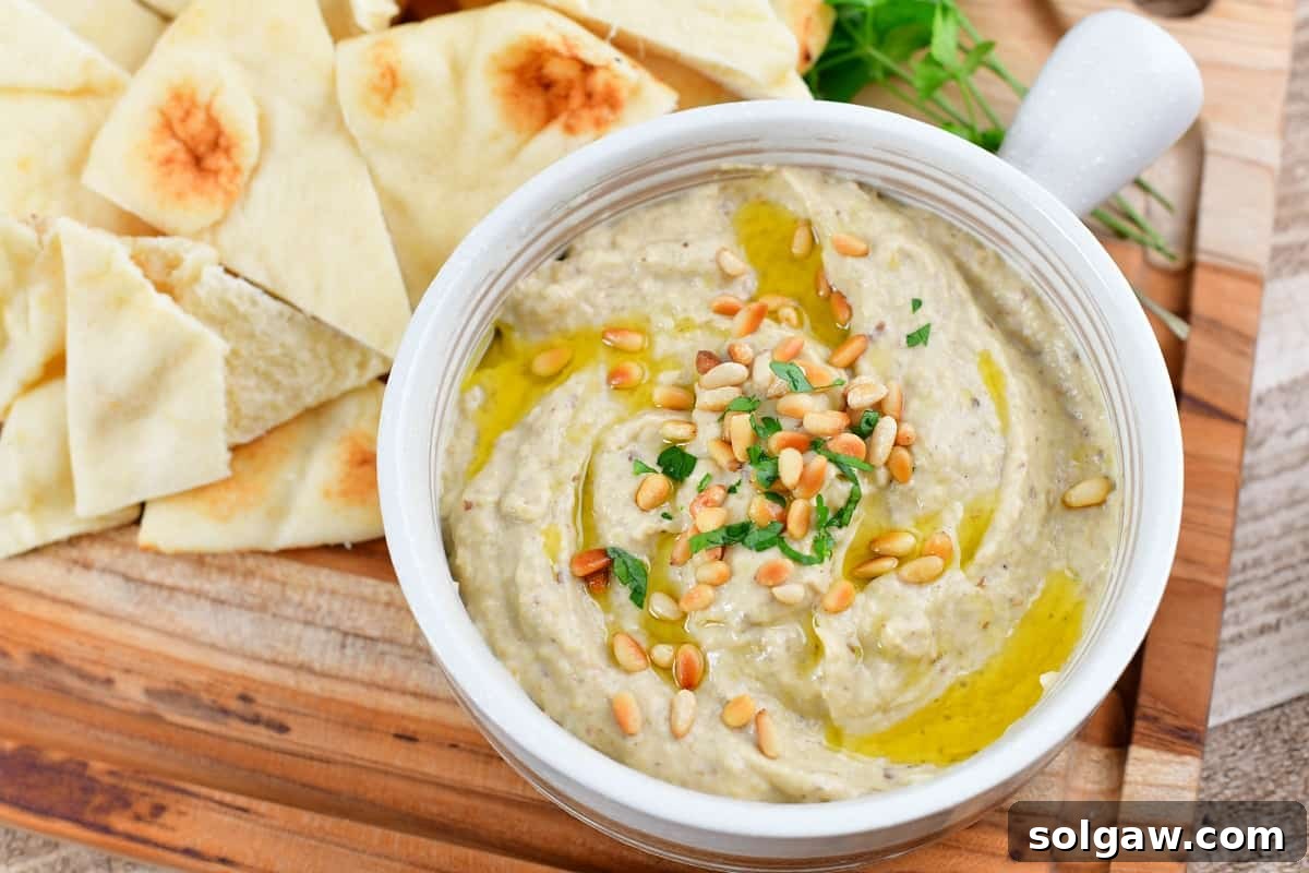 Smoky Aubergine Mezze 10 Close-up of a bowl of creamy Baba Ganoush with a swirl of olive oil and pine nuts
