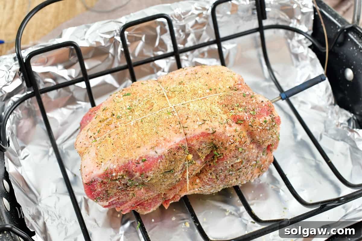 seasoned and tied pork shoulder in the roasting pan.