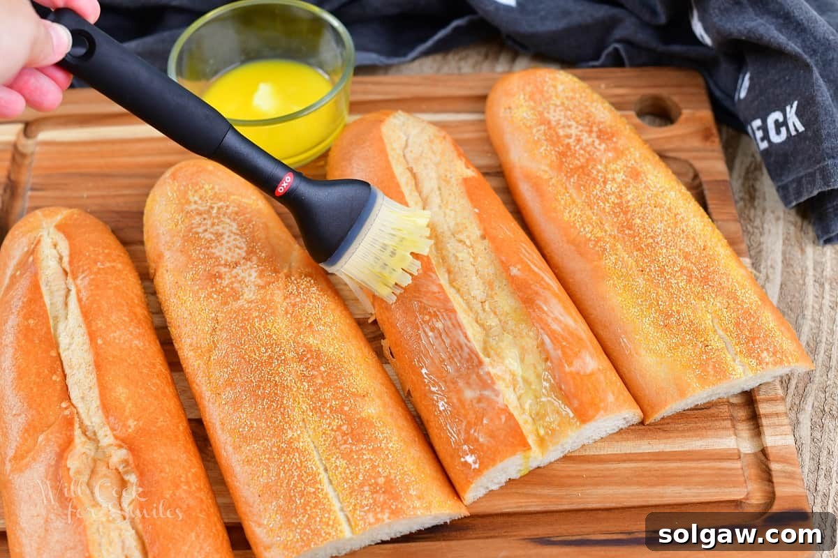 brushing tops of Cuban bread with butter for a Cuban sandwich