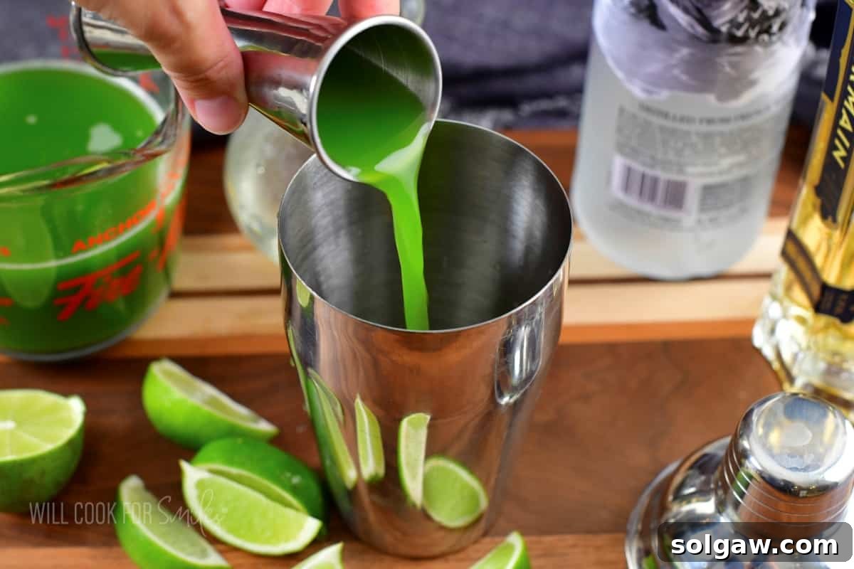 Adding fresh cucumber juice to a cocktail shaker.