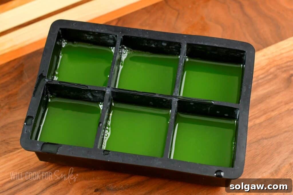 Cucumber juice frozen in a black ice cube mold.