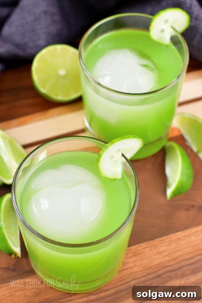 Top view of two bright green cucumber cocktails in glasses.
