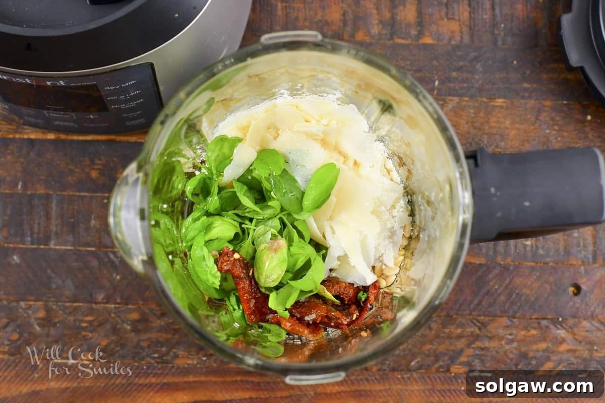 Combined ingredients for a flavorful tomato pesto in a blender, ready for pulsing.