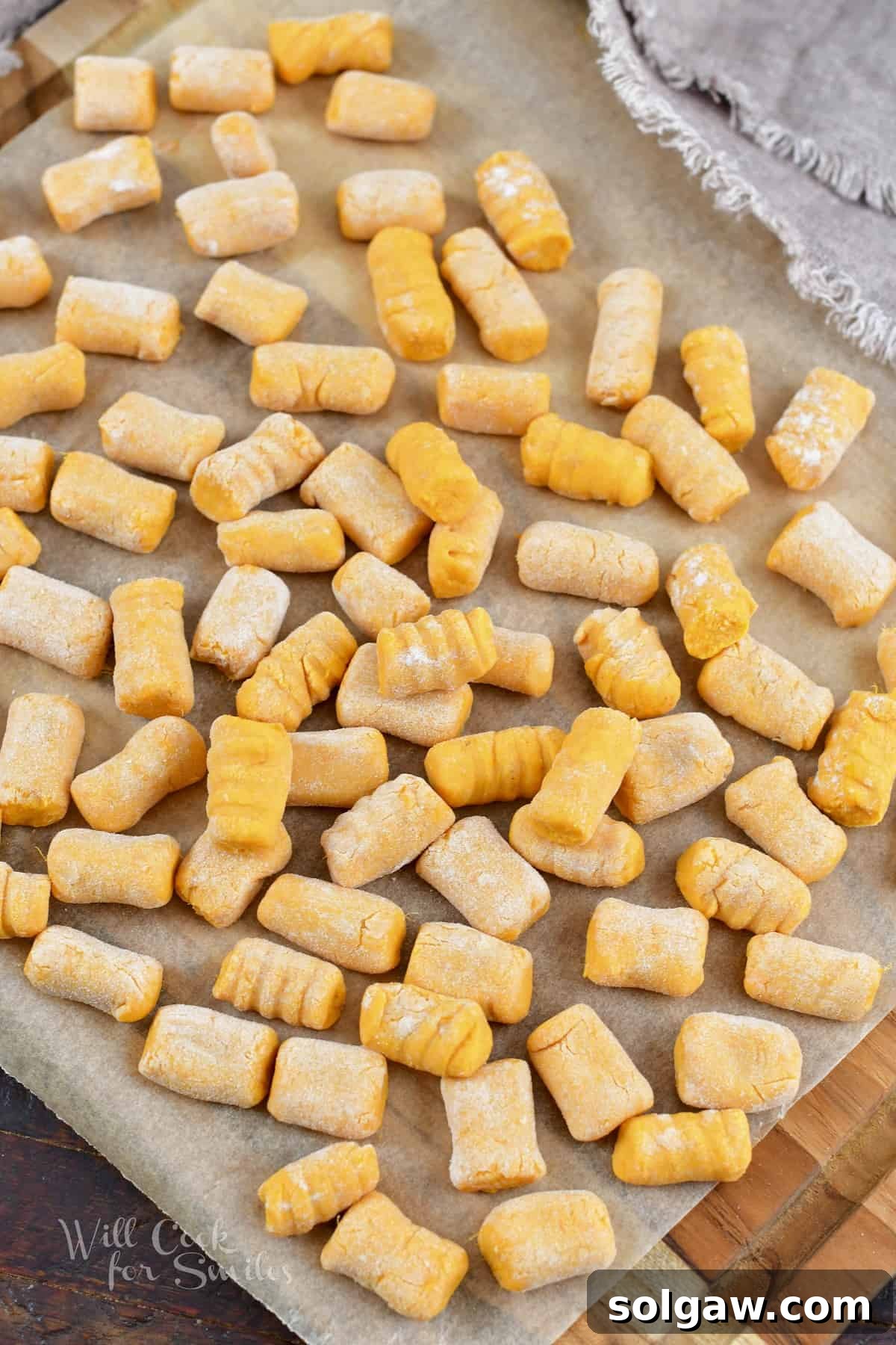 Top view of homemade sweet potato gnocchi spread out on parchment paper, ready for cooking or freezing.