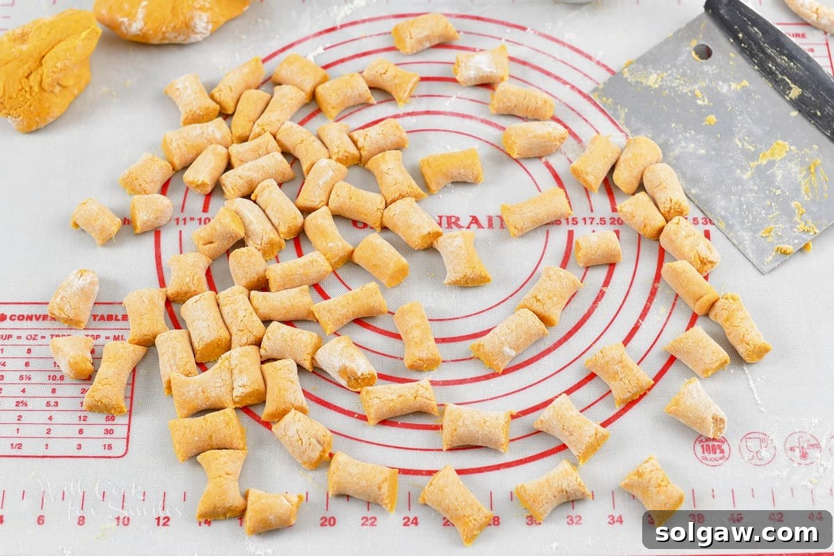 Sweet potato gnocchi ropes cut into small, pillow-like pieces.