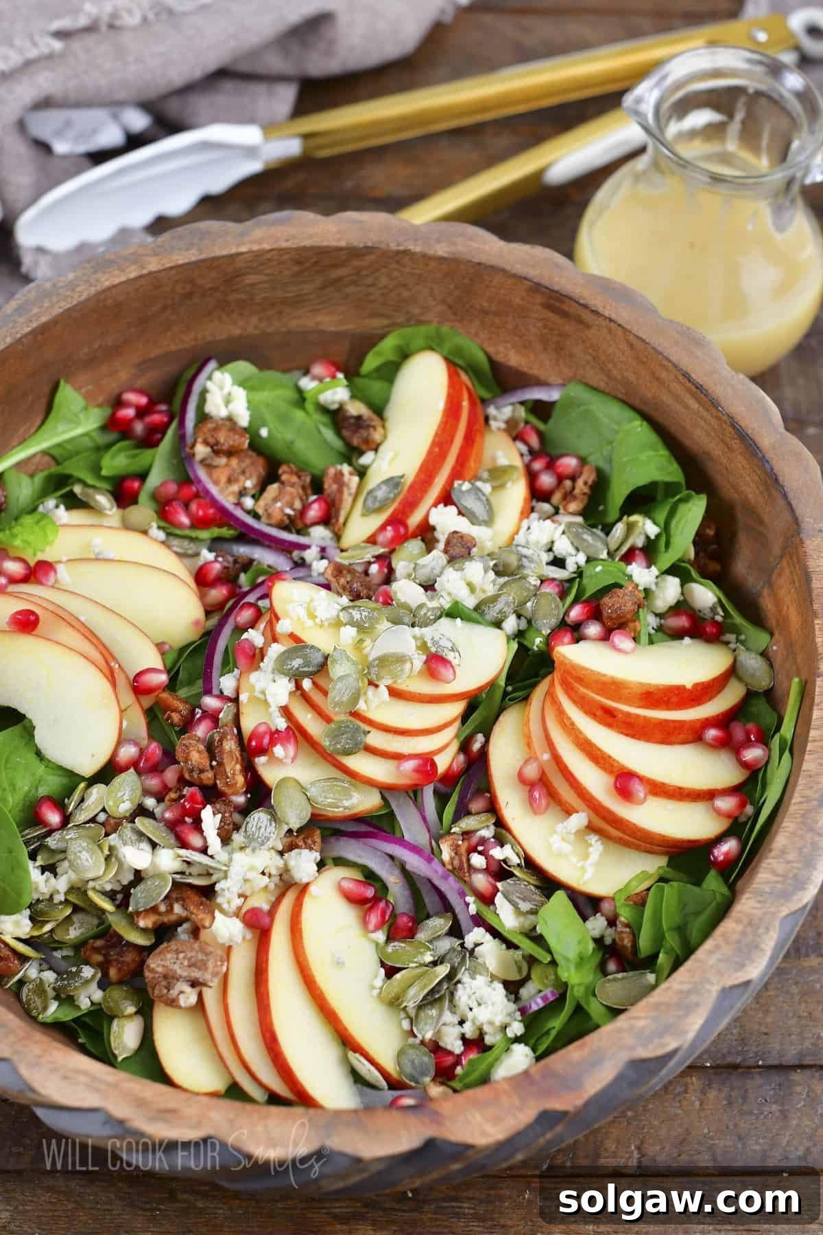 Orchard Apple Bliss 2 Top view of a vibrant apple salad with apples, pecans, and pomegranate seeds in a wooden bowl.
