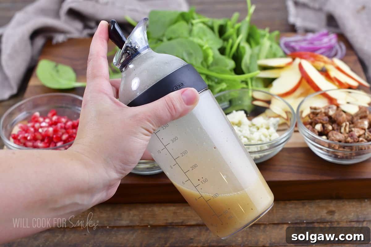 Orchard Apple Bliss 4 A hand shaking a bottle of homemade apple cider dressing.