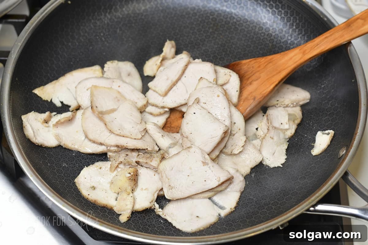 Turkey Reuben Melt 4 Sautéing thinly sliced turkey breast in a pan before assembling the Turkey Reuben sandwich.