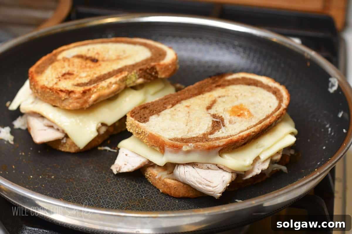 Turkey Reuben Melt 8 Two golden-brown Turkey Reuben sandwiches cooking in a hot pan, pressed gently to meld the flavors.