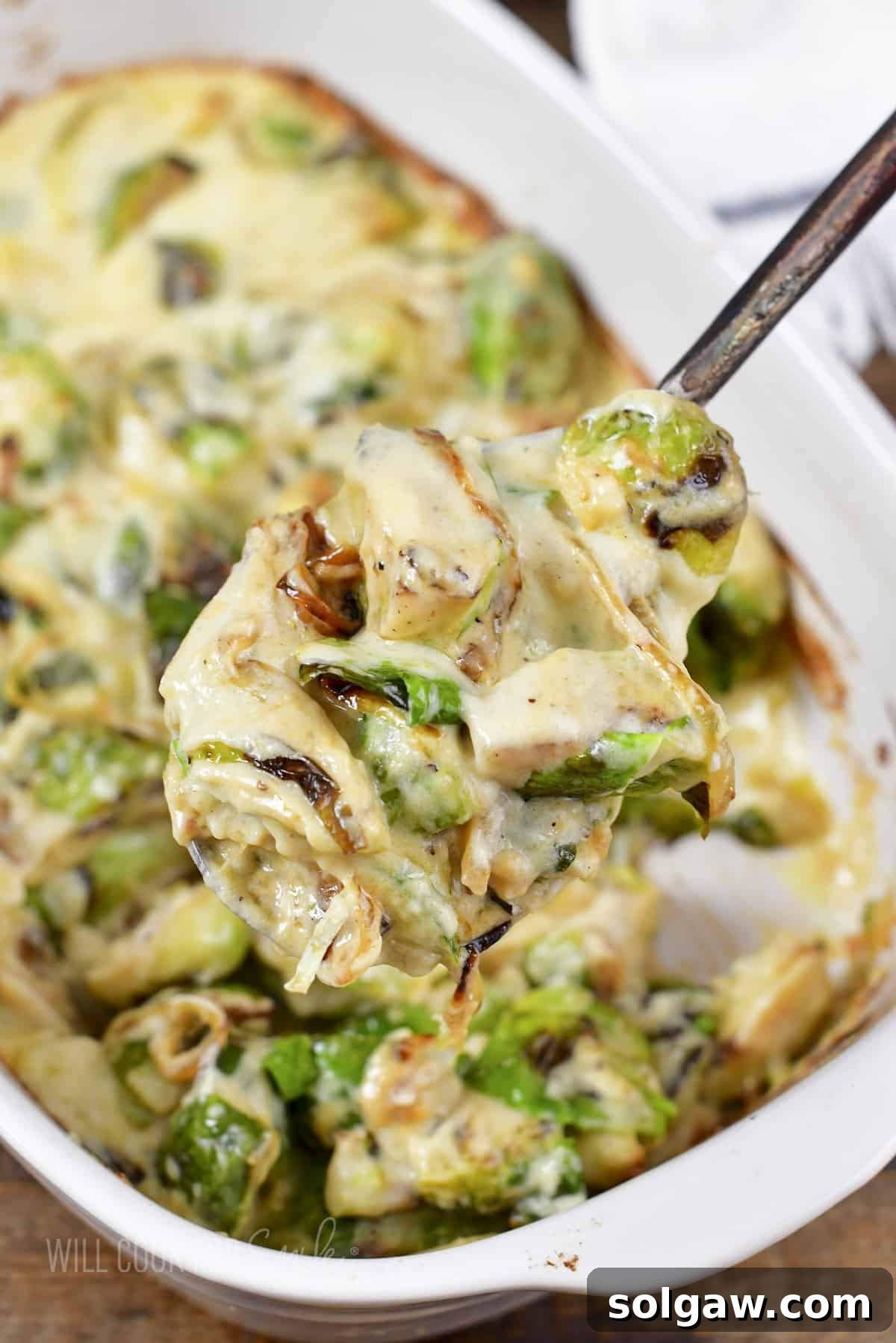 Velvety Baked Brussels Sprouts Gratin 8 creamy brussels on a ladle out of the baking dish.