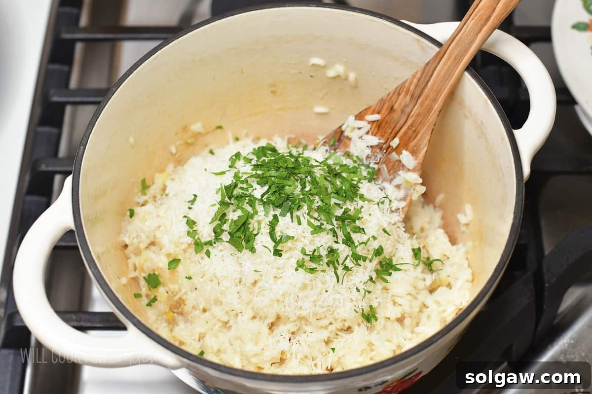 Velvety Parmesan Rice 11 Cooked creamy rice with parmesan cheese and parsley in a pot, ready to be served.