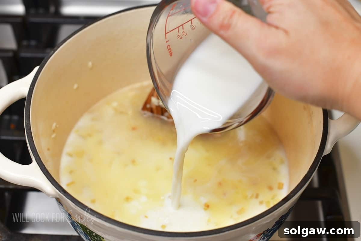 Velvety Parmesan Rice 6 Pouring warmed milk into the pot with sautéed rice, onions, and garlic.