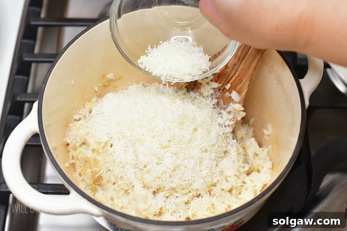 Velvety Parmesan Rice 10 Adding freshly grated parmesan cheese to a pot of cooked creamy rice.