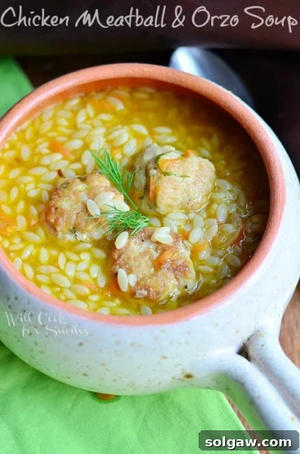 Chicken Meatball Orzo Soup in a white bowl with a green napkin
