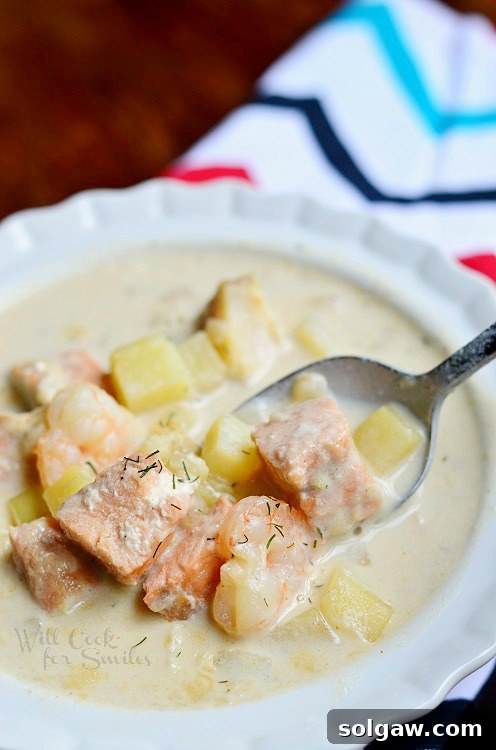 Seafood Chowder Soup in a white bowl with a spoon scooping some