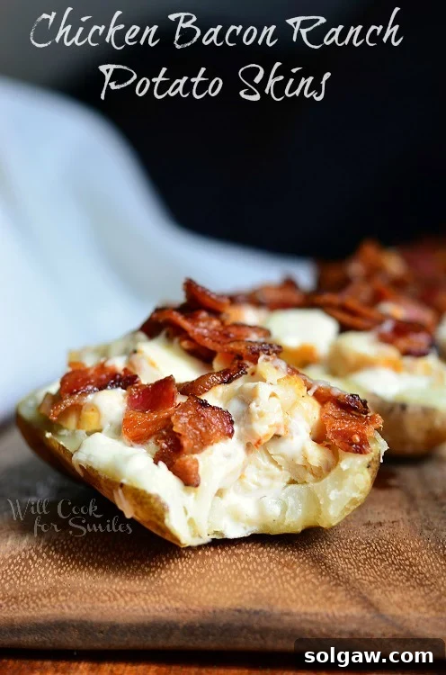 Ultimate Chicken Bacon Ranch Potato Skins 2 Chicken Bacon Ranch Loaded Potato Skins on a wood cutting board, showcasing a full plate ready to serve