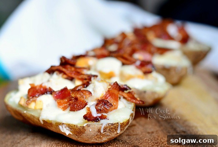 Ultimate Chicken Bacon Ranch Potato Skins 3 Horizontal shot of four Chicken Bacon Ranch Loaded Potato Skins on a rustic wooden cutting board