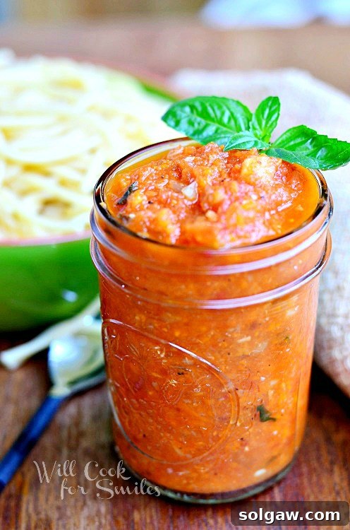 Homemade Marinara sauce in a glass jar, perfectly sealed, with fresh basil leaves arranged elegantly on the side. The image suggests freshness and homemade quality.