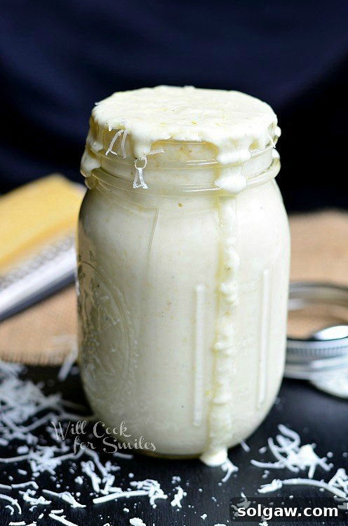 A mason jar filled with creamy, homemade Alfredo sauce, ready to be enjoyed with pasta or other Italian dishes.