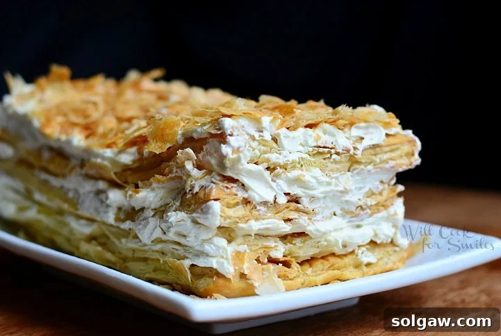 Classic Napoleon Cake 3 Close-up shot of a slice of Napoleon Cake, showcasing its multiple flaky layers and creamy white frosting.