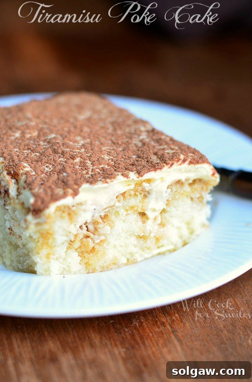 Classic Napoleon Cake 6 Tiramisu Poke Cake on a white plate with a slice removed, showing creamy layers.