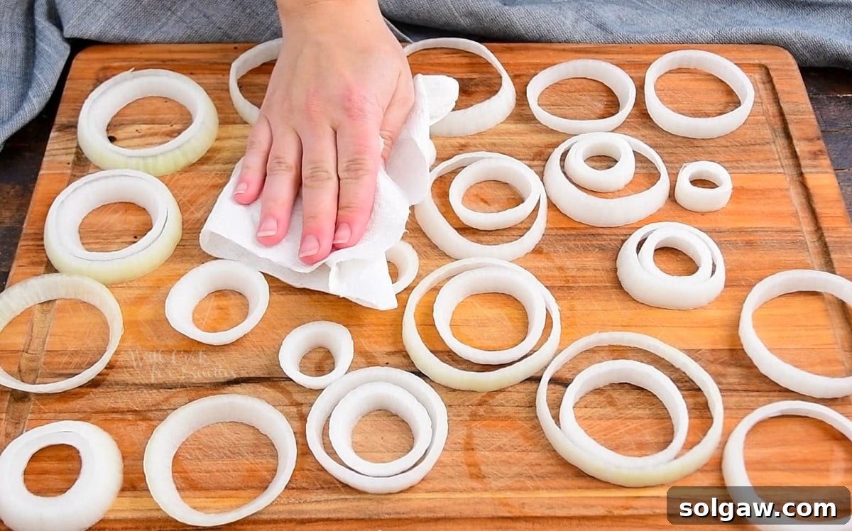 patting rings of onion with paper towel