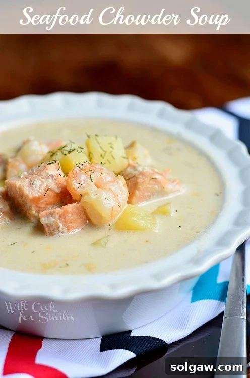 A rich and creamy Seafood Chowder Soup in a white bowl, garnished with fresh herbs.