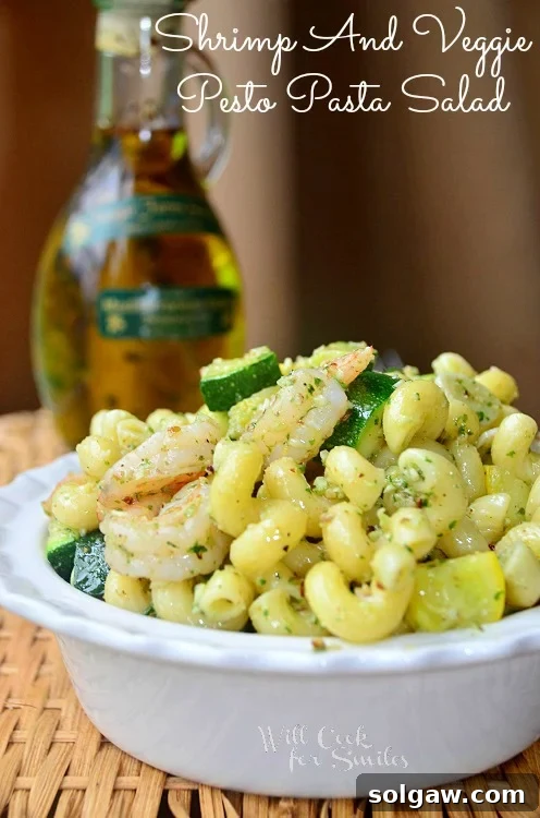 A fresh Shrimp and Veggie Pesto Pasta Salad in a white bowl, vibrant and appealing.