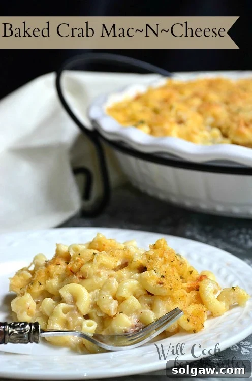 A delectable baked crab mac and cheese on a white plate with a fork, showing its cheesy goodness.
