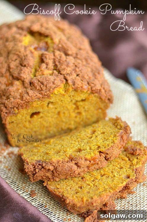 Biscoff Cookie Pumpkin Bread on a cutting board, with crumbs and a knife