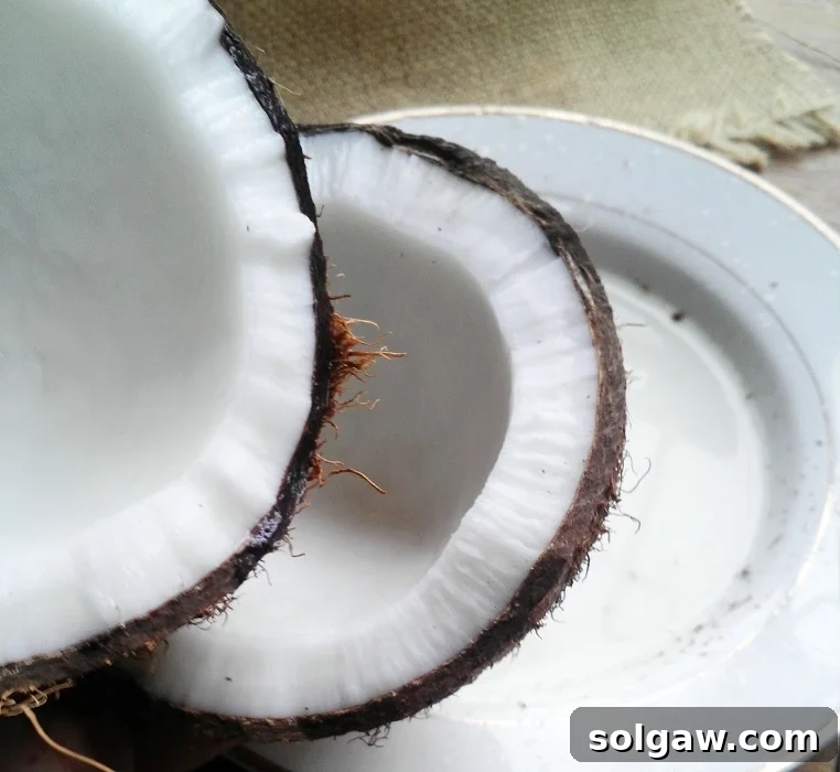 Sun-Kissed Coconut Key Lime Loaf 3 coconut cracked in half on a white plate