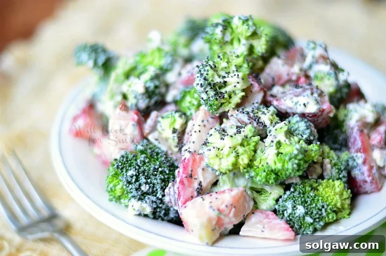 Close-up of Strawberry Broccoli Salad on a plate with a fork, emphasizing the texture and vibrant colors.