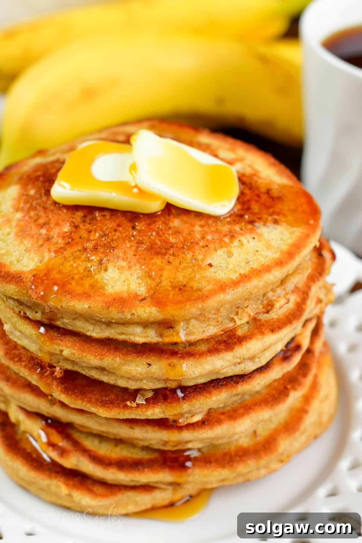stack of several blender oatmeal pancakes topped with butter and syrup.